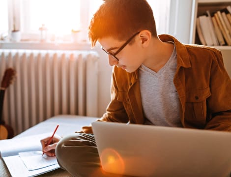 El estudiante que tomaba notas comía en casa con su ordenador portátil.